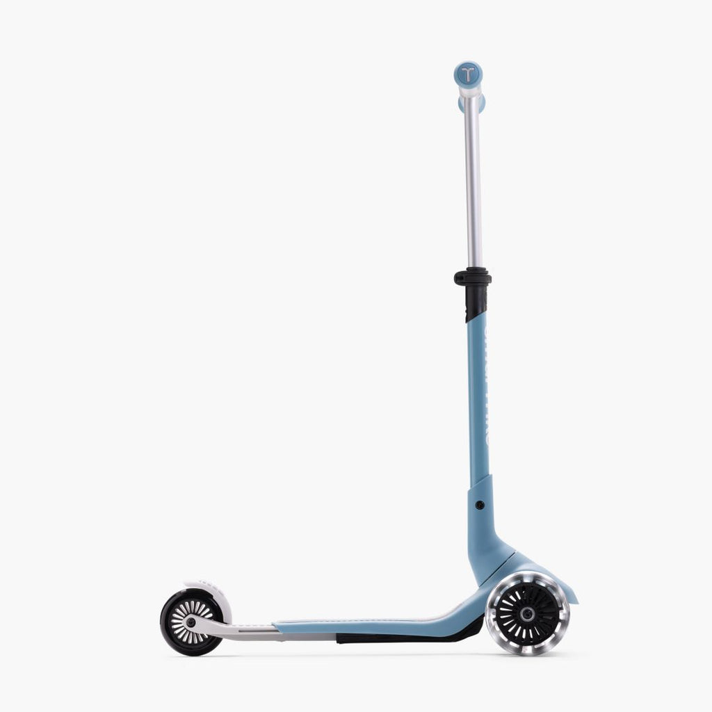 Vista lateral del scooter SmarTrike Xtend Mini+ Celeste en modo scooter con manubrio y plataforma extendidos al máximo y ruedas LED. Fondo blanco.