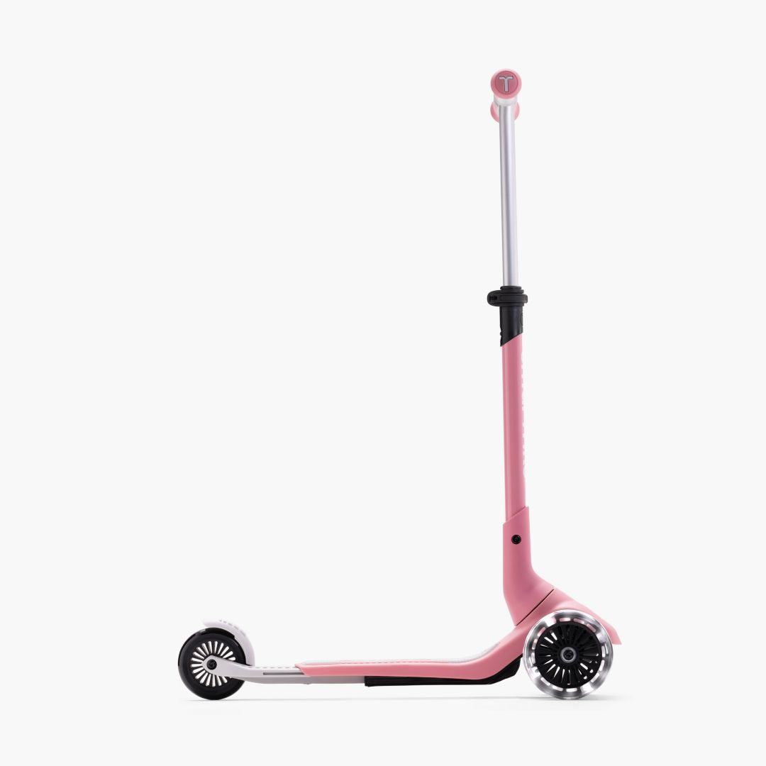 Vista lateral del scooter SmarTrike Xtend Mini+ Palo Rosa en modo scooter con manubrio y plataforma extendidos al máximo y ruedas LED. Fondo blanco.