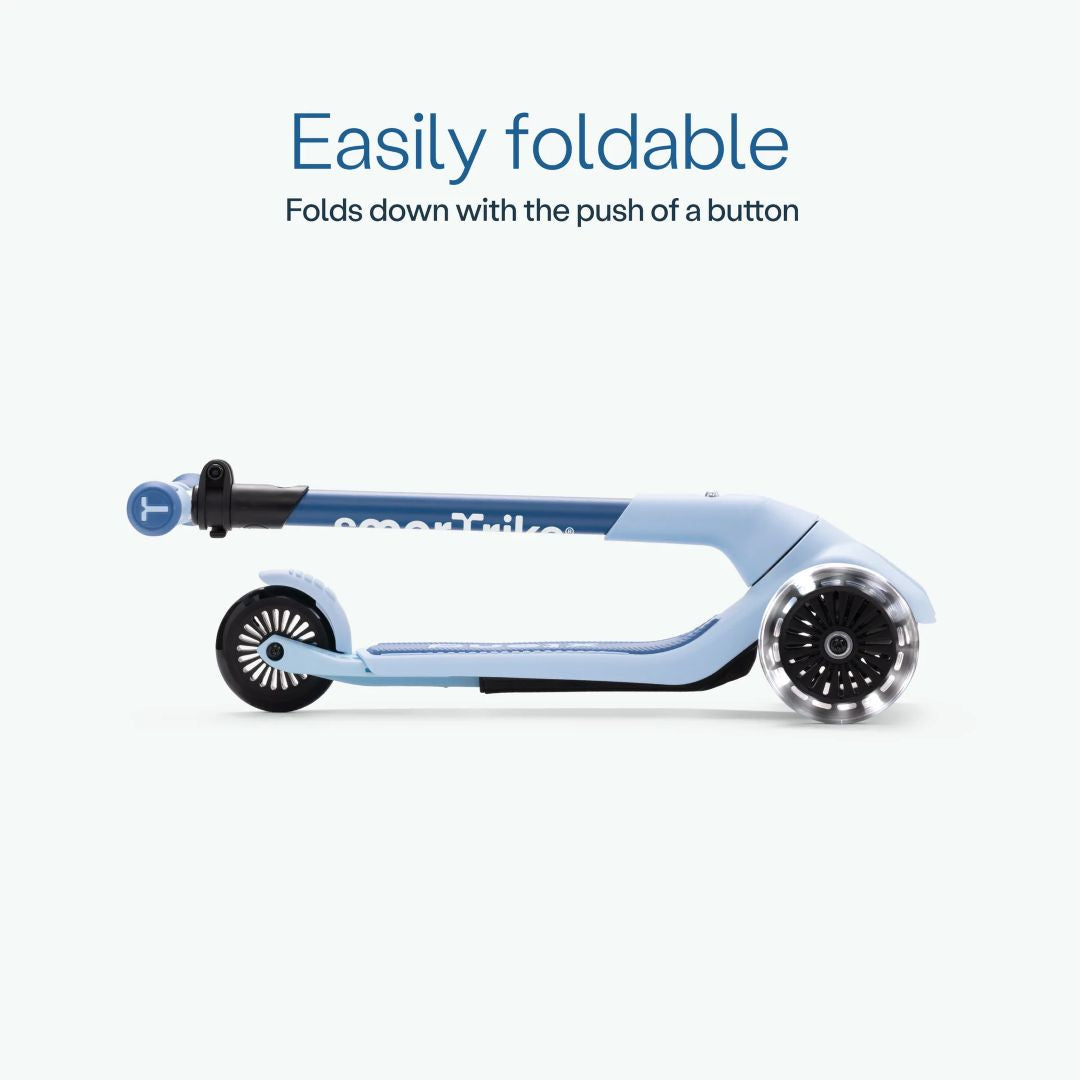 Vista lateral del scooter SmarTrike Xtend Mini Ride color Celeste completamente plegado, mostrando su diseño compacto. Texto: "Easily foldable. Folds down with the push of a button."