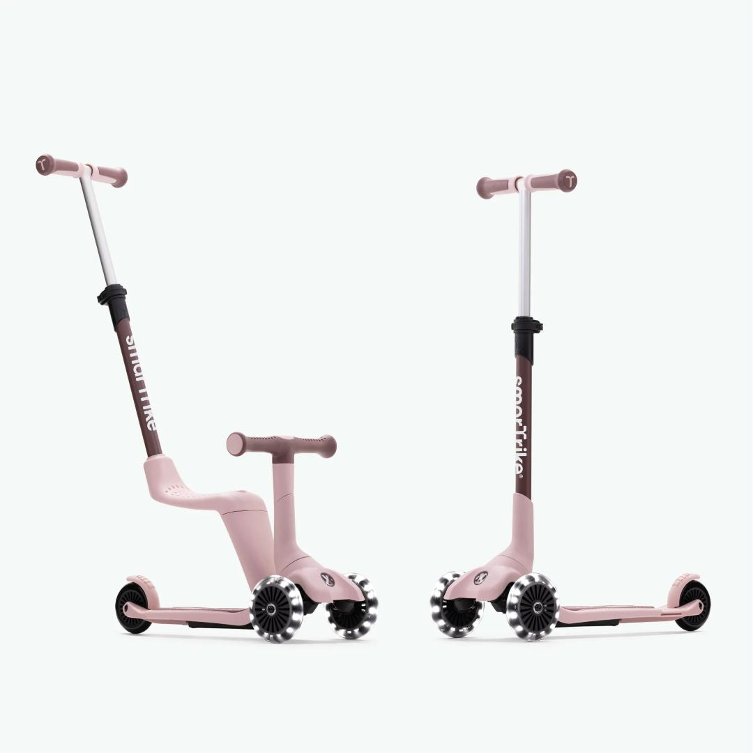Dos vistas del scooter evolutivo SmarTrike Xtend Mini Ride en color Pola Rosa: a la izquierda en modo correpasillos con asiento y manubrio para padres inclinado, y a la derecha en modo scooter autónomo con manubrio vertical y ruedas LED. Fondo verde muy claro.