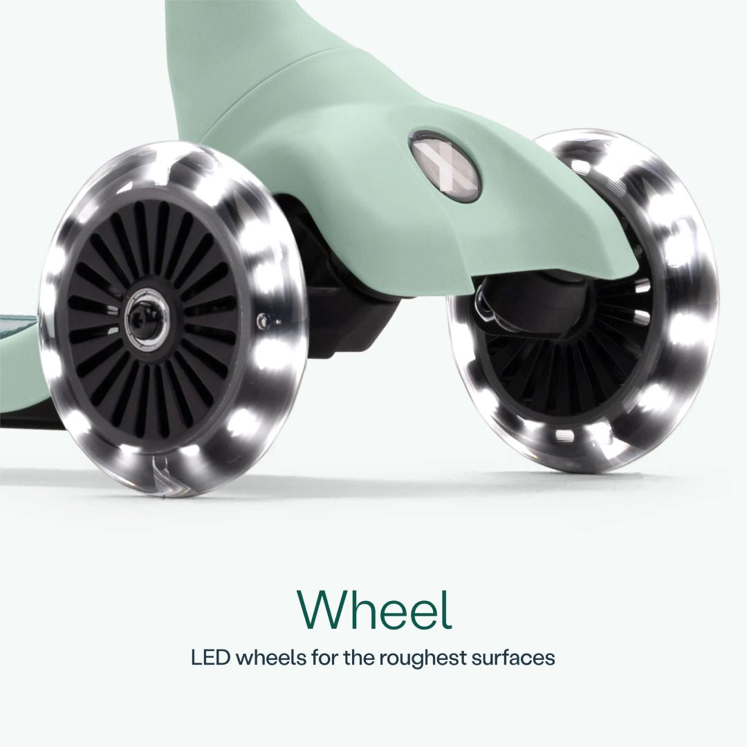 Detalle de las dos ruedas delanteras con luz LED del scooter SmarTrike Xtend Mini Ride en color Verde Agua, sobre fondo verde claro. Texto: "Wheel. LED wheels for the roughest surfaces."