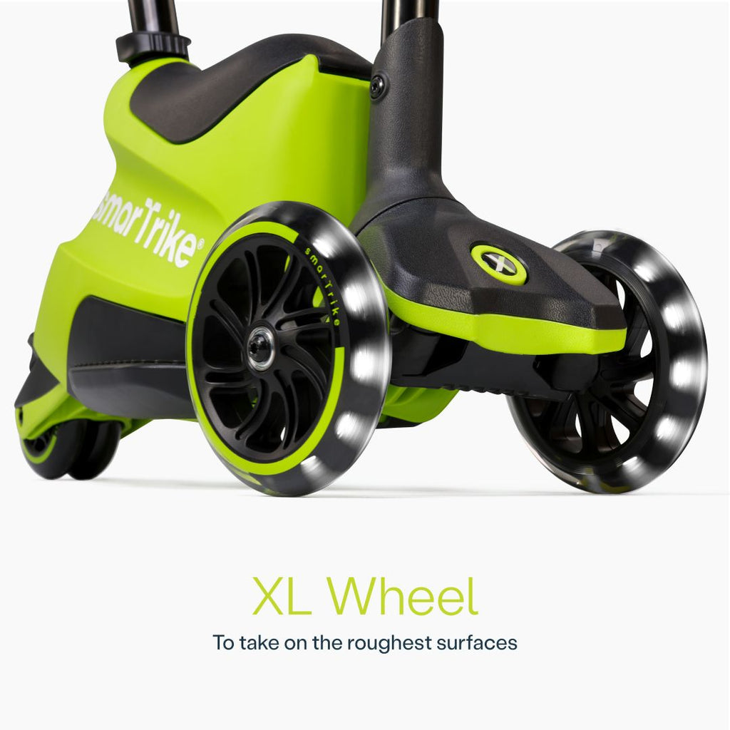 Detalle en primer plano de las ruedas XL con luz LED del scooter evolutivo SmarTrike Xtend Ride-On Lima, con cuerpo gris y negro y logo de la marca. Texto: "XL Wheel. To take on the roughest surfaces." Fondo blanco.
