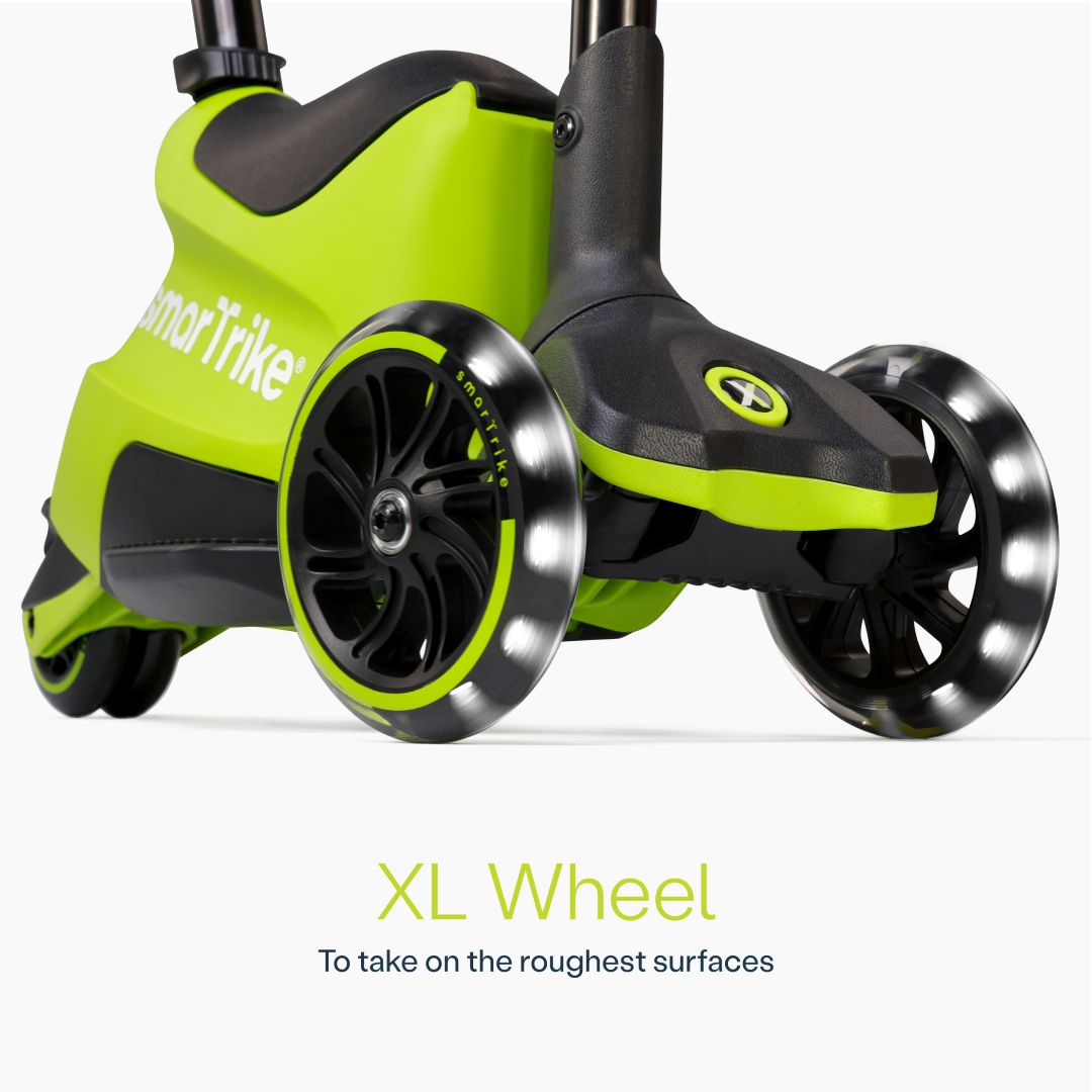 Detalle en primer plano de las ruedas XL con luz LED del scooter evolutivo SmarTrike Xtend Ride-On Lima, con cuerpo gris y negro y logo de la marca. Texto: "XL Wheel. To take on the roughest surfaces." Fondo blanco.