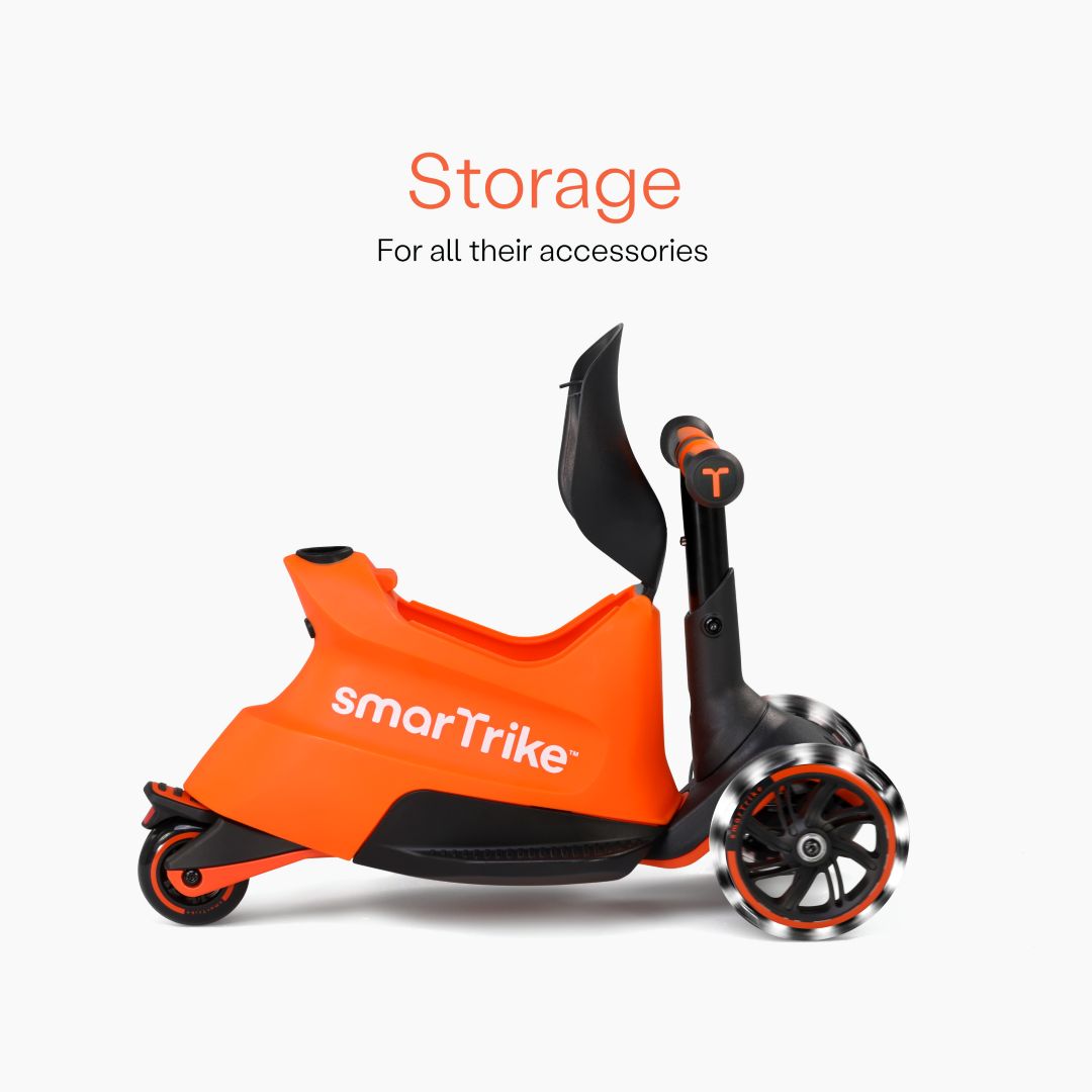 Vista lateral del scooter SmarTrike Xtend Ride-On Naranjo en modo ride-on mostrando el compartimento de almacenamiento abierto bajo el asiento y ruedas LED. Texto: "Storage. For all their accessories." Fondo blanco.