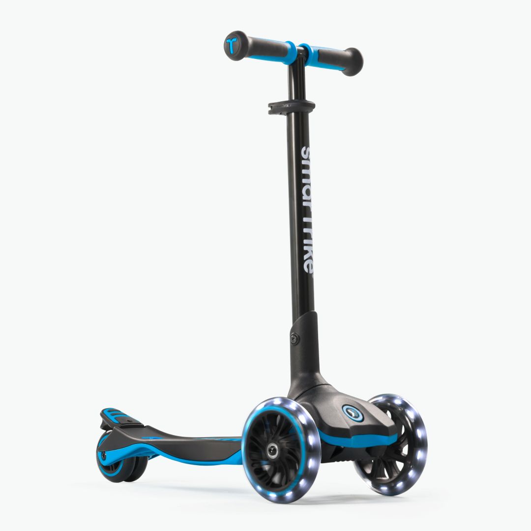 Vista frontal en ángulo del scooter evolutivo SmarTrike Xtend en color azul, plataforma extensible patentado, tres ruedas XL con luz LED y plataforma antideslizante. Fondo gris claro.