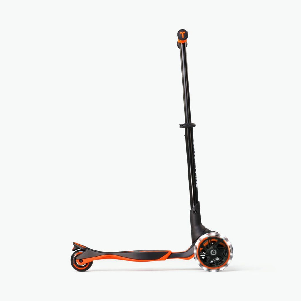 Vista lateral del scooter evolutivo SmarTrike Xtend naranja con manubrio extendido al máximo, plataforma  en posición avanzada y ruedas LED, en configuración para niños mayores. Fondo blanco