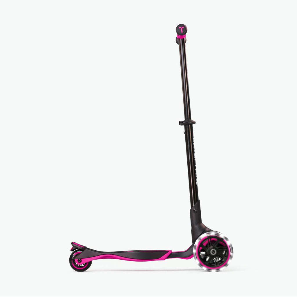 Vista lateral del scooter evolutivo SmarTrike Xtend rosa con manubrio extendido al máximo, plataforma  en posición avanzada y ruedas LED, en configuración para niños mayores. Fondo blanco