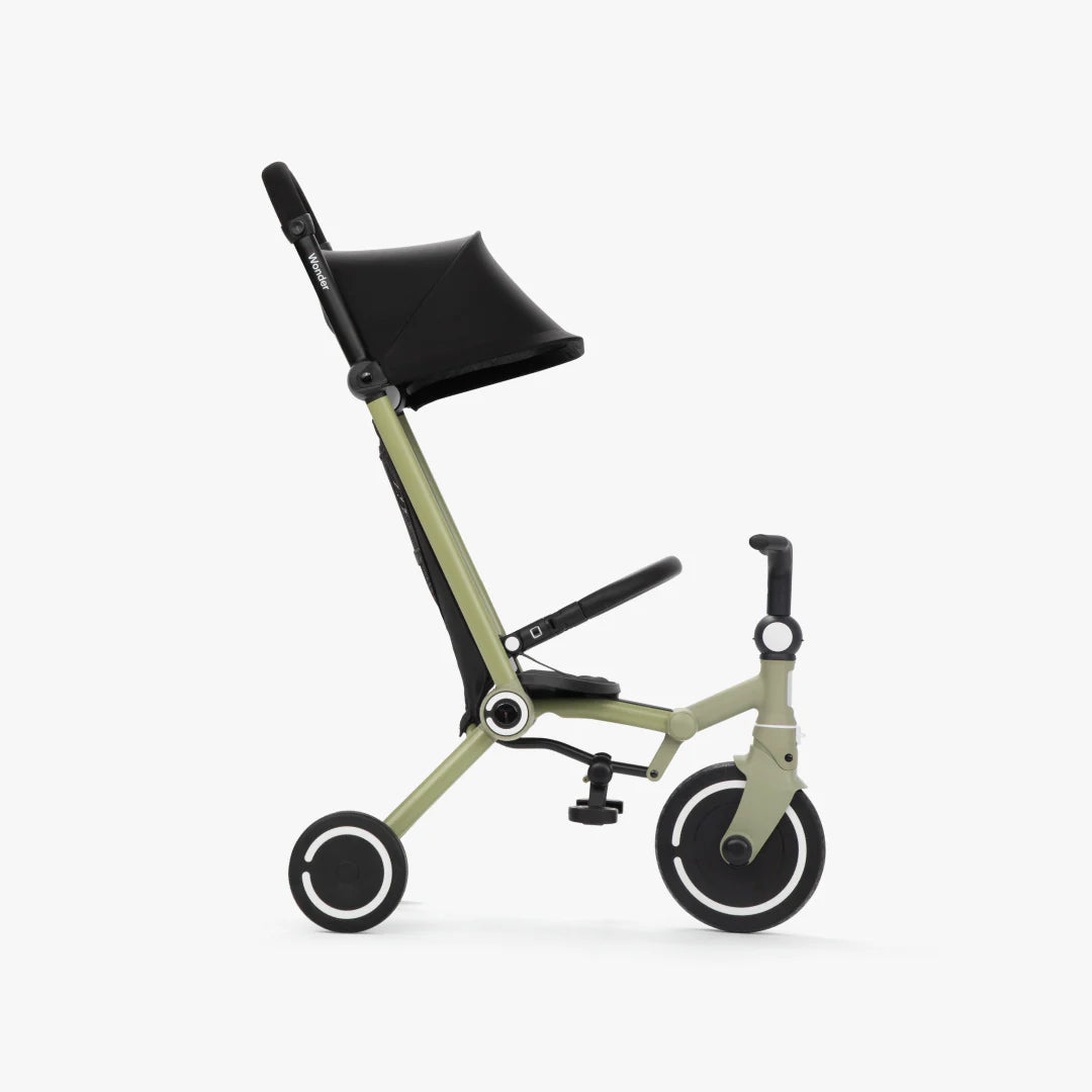 Coche triciclo evolutivo SmarTrike Wonder color olive, plegable, apto para cabina de avión, uso desde los 9 meses, con dirección Easy-Steer 360° patentado, panel de malla transpirable, manubrio para padres, asiento con reposapiés y tres ruedas con aros blancos, fotografiado, en modo coche, ángulo lateral sobre fondo blanco.