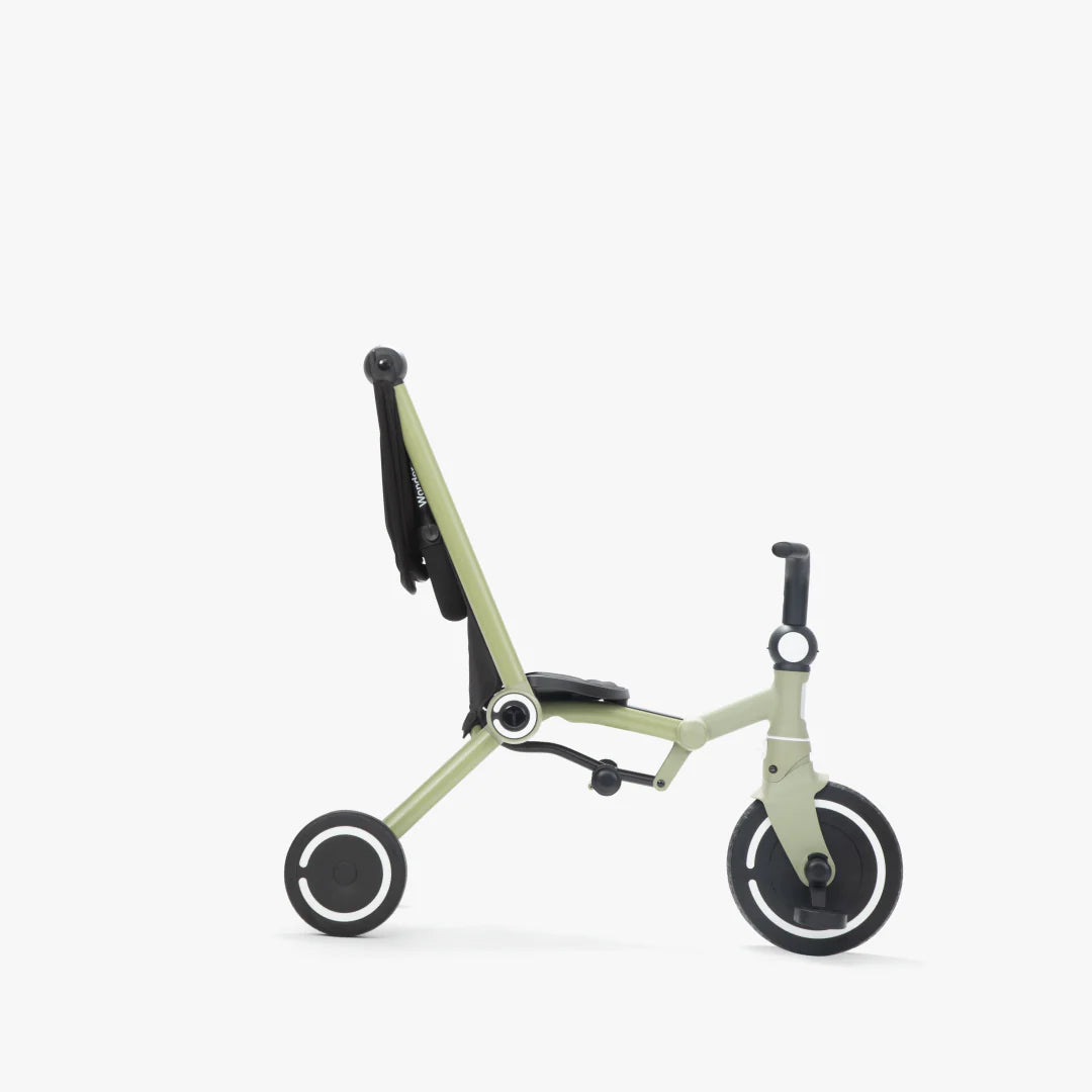 Coche triciclo evolutivo SmarTrike Wonder color olive, plegable, apto para cabina de avión, uso desde los 9 meses, con dirección Easy-Steer 360° patentado, panel de malla transpirable, manubrio para padres, asiento con reposapiés y tres ruedas con aros blancos, fotografiado, en modo triciclo, ángulo lateral sobre fondo blanco.