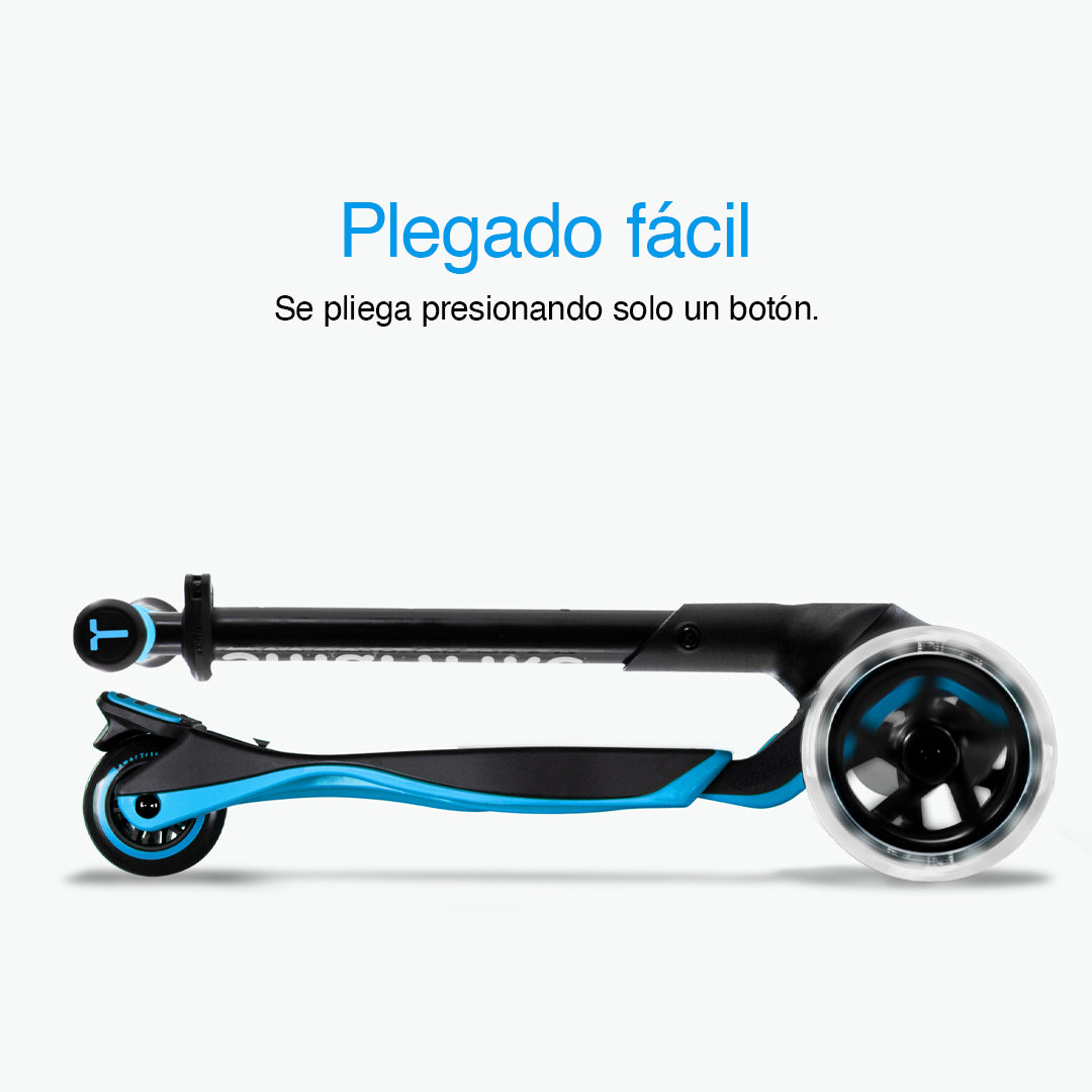 Vista lateral del scooter SmarTrike Xtend azul completamente plegado en formato compacto con ruedas LED visibles. Texto: "Plegado fácil. Se pliega con solo presionar un botón." Fondo gris claro.