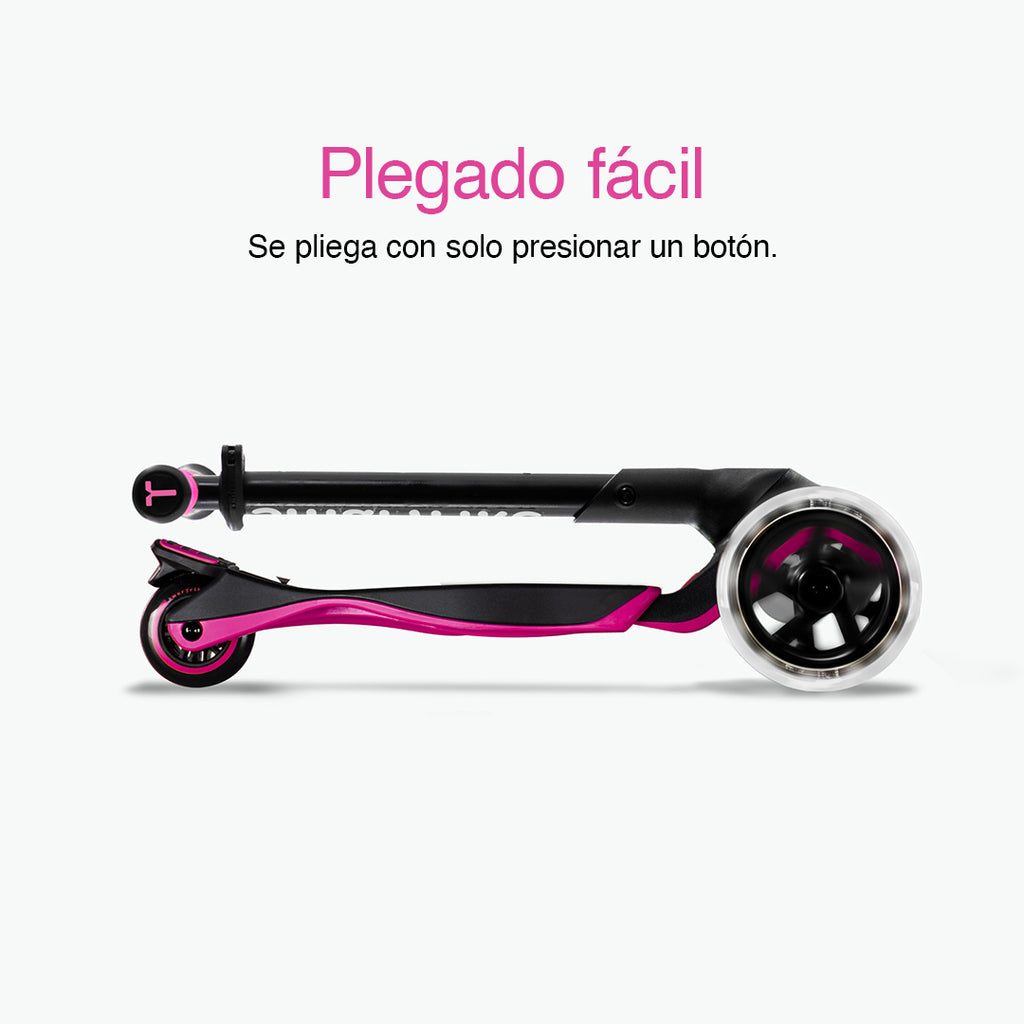 Vista lateral del scooter SmarTrike Xtend rosa completamente plegado en formato compacto con ruedas LED visibles. Texto: "Plegado fácil. Se pliega con solo presionar un botón." Fondo gris claro.